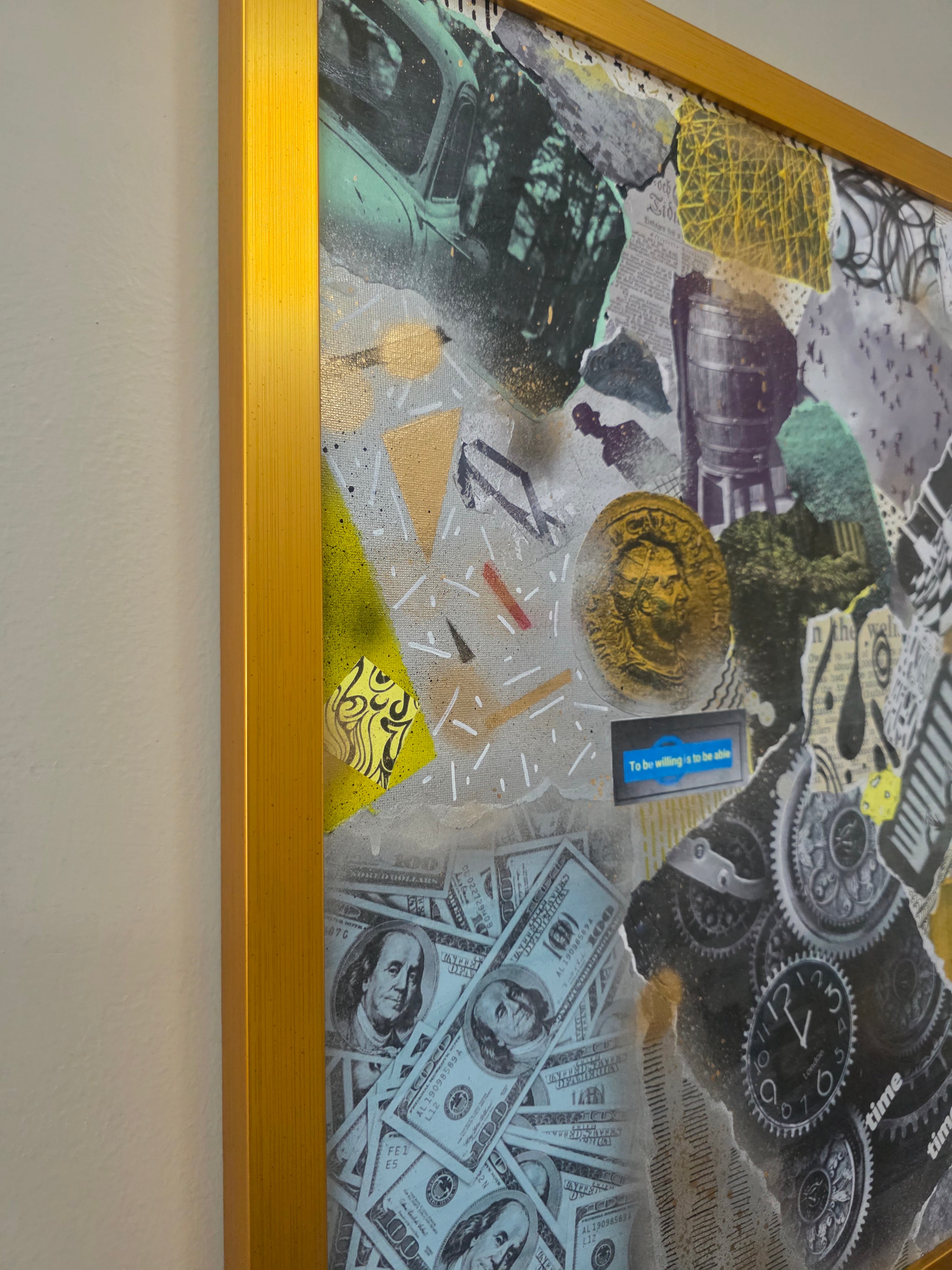 Framed collage with various items including coins and dollar bills on a wall.