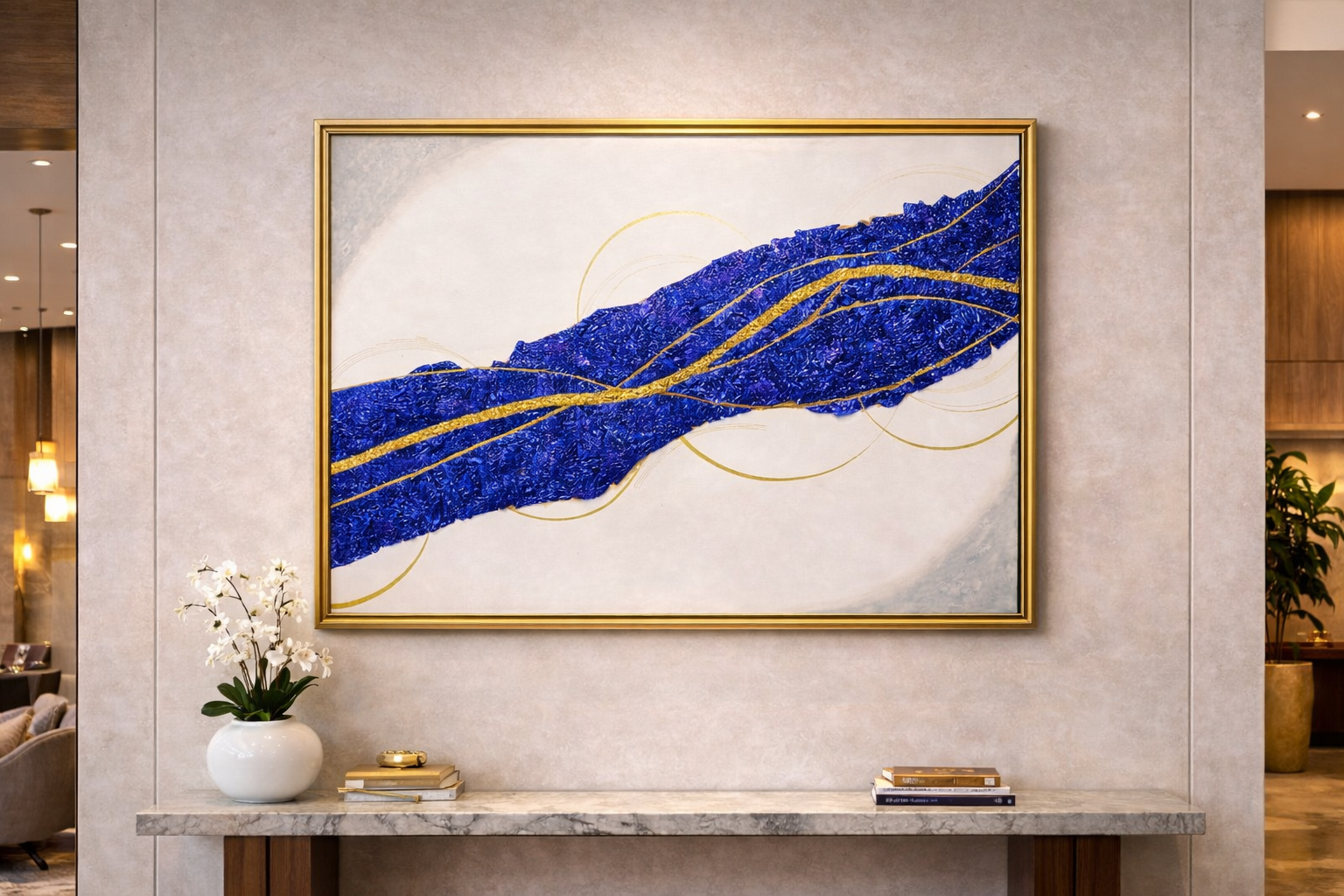 Abstract art piece with blue and gold design on a wall in an interior setting.