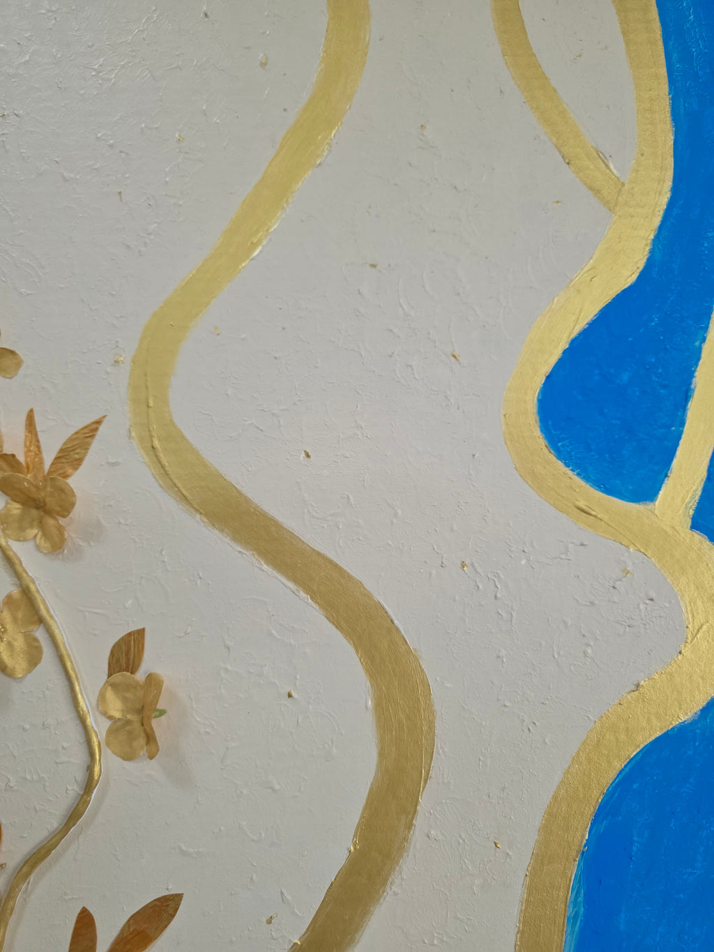 Decorative wallpaper with wavy blue and gold patterns on a textured white background