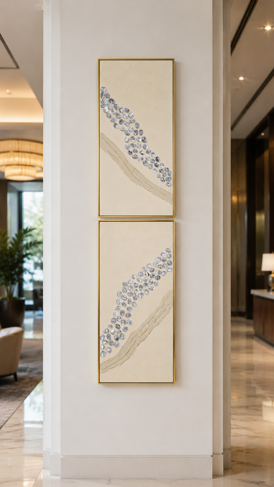 Luxury hotel lobby pillar featuring a vertical twin set of abstract art in slim gold frames, minimalist white interior design.