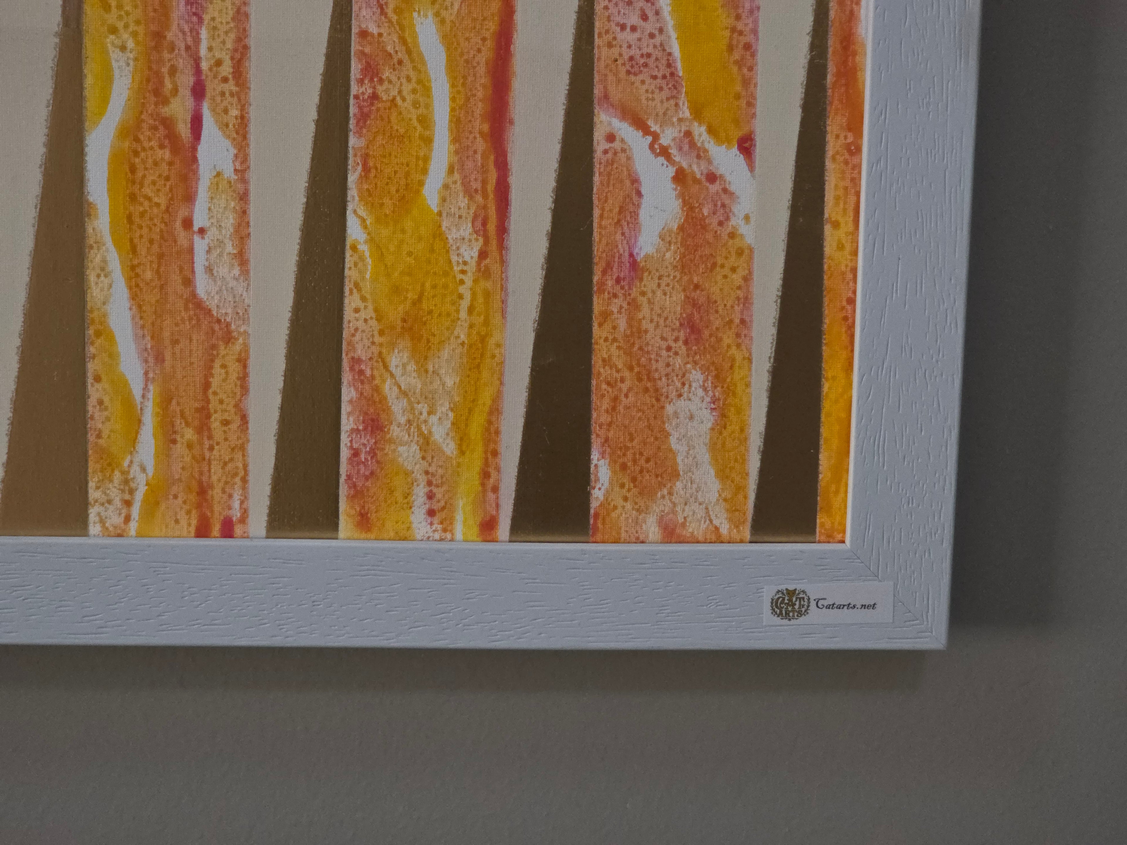 Framed abstract artwork with orange and yellow patterns on a gray background