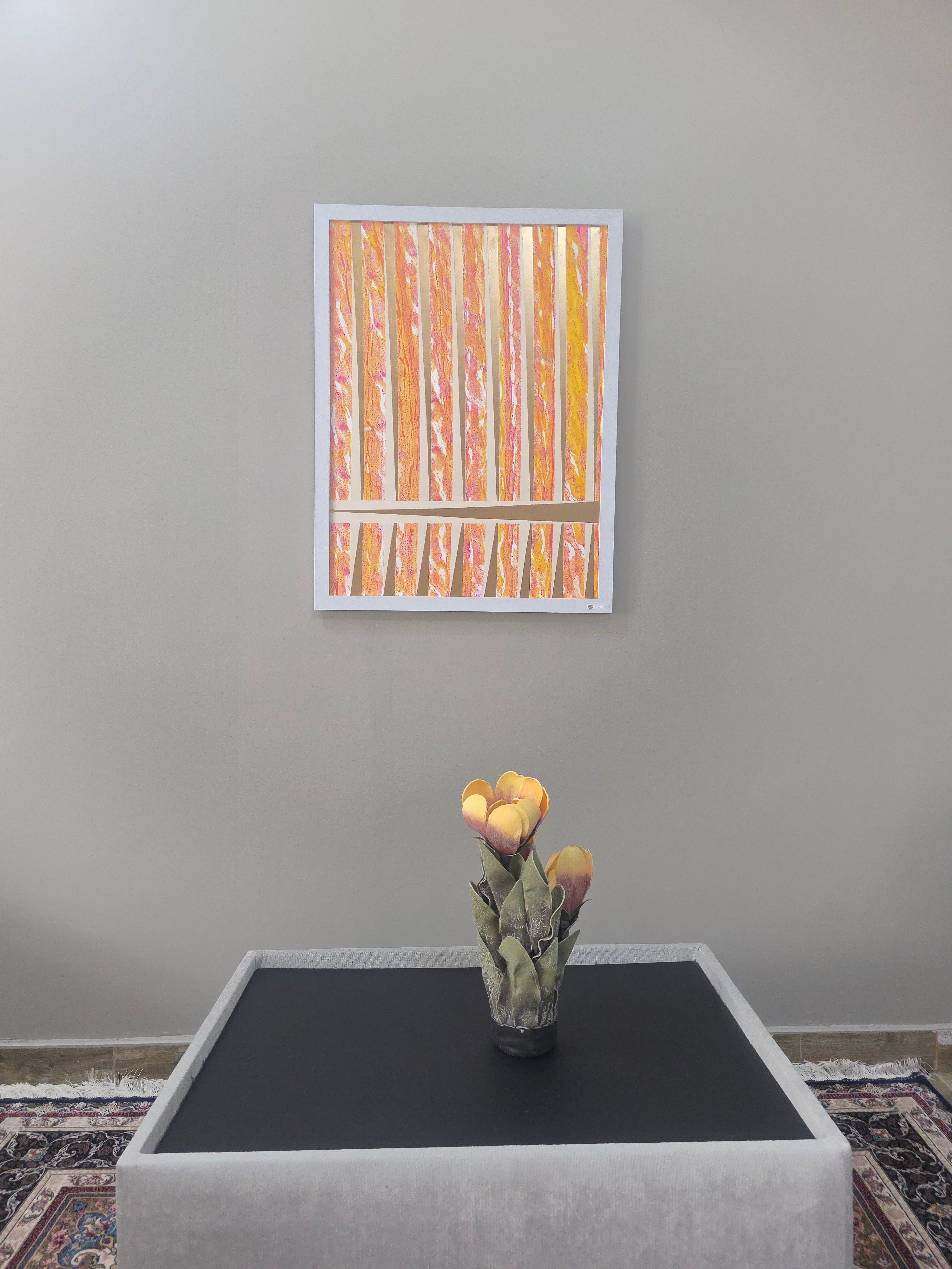 Framed abstract artwork on a wall next to a television in a room.