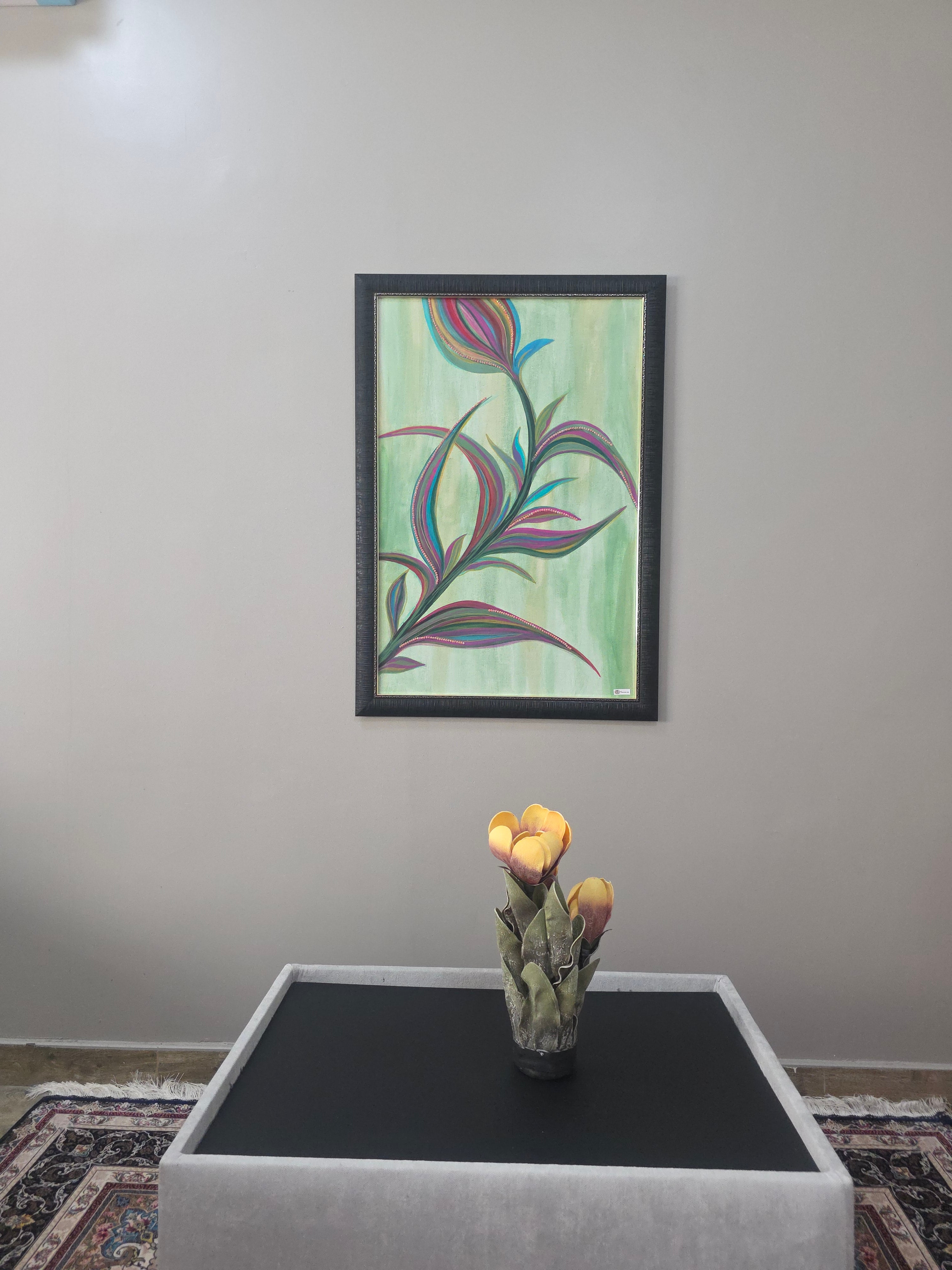 Framed abstract plant artwork on a wall next to a table with a decorative item.