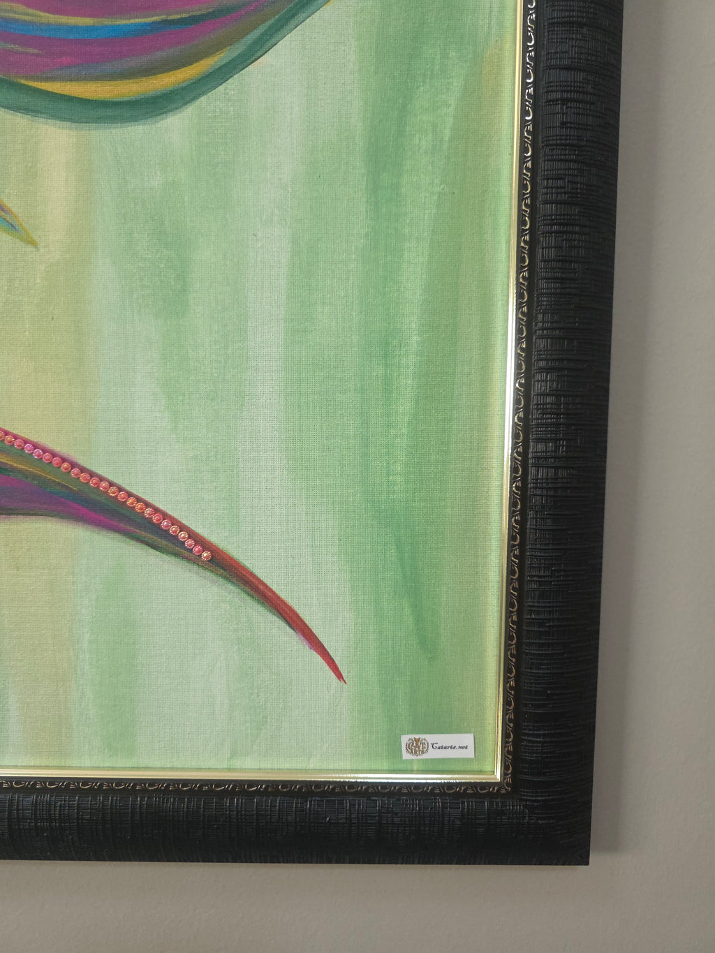 Framed artwork with a colorful leaf design on a green background