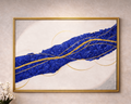 Framed abstract artwork with blue and gold design on a beige wall