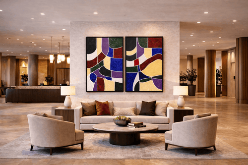 Architectures of Color, a large-scale textured abstract diptych in blue, burgundy, and gold, displayed in a luxury hotel lobby above a cream sofa.
