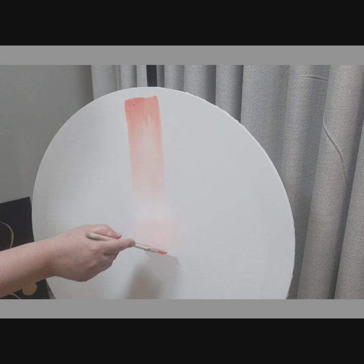Video demonstrating the CatArts artisanal painting process as a paintbrush applies a soft peach stroke to a large round canvas
